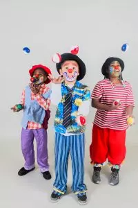 three children in clown make up juggling bean bags