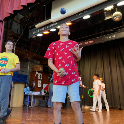 Prescott Circus Theatre student practicing juggling on stage during class lesson, 2024.