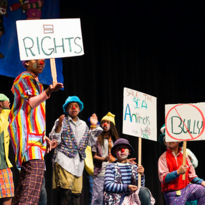 Prescott Circus student clowns in mock protest performance on stage at Prescott Circus Theatre's Annual Spring Showcase.